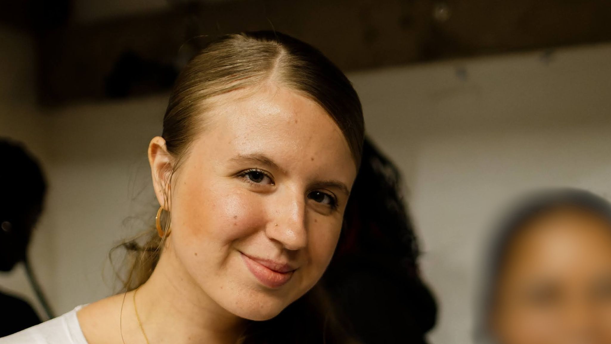 Isla at the Yard theatre A young lady in a white shirt looking directly at the camera and smiling